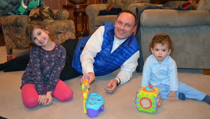 Father Tom Puslecki, of Innisfail&#8217;s Our Lady of Peace Catholic Church, relaxes and plays with two-year-old Antounyo Kahwate and his seven-year-old sister Etwal.