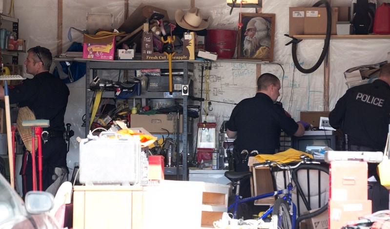 Calgary Police Service officers search the garage of a home in Carstairs on the afternoon of March 5.