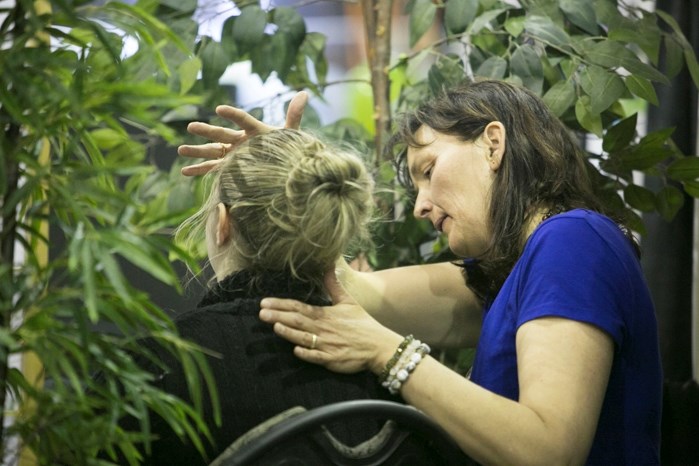 Manuela Schaedeli, right, performs craniosacral therapy on a visitor to her booth during last weekend&#8217;s Innisfail and District Trade Show.