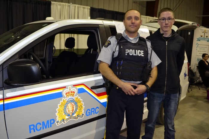 Erich Marcinkowski, 16, and Innisfail RCMP Const. Pascal Bedard at the Innisfail and District Trade Show last month. Through a school work program Marcinkowski has been