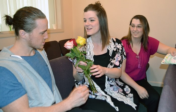 Chantelle Langdon, a Fort McMurray evacuee, holds a bouquet of flowers that were given to women for Mother&#8217;s Day during last Sunday&#8217;s service at the River of Life 