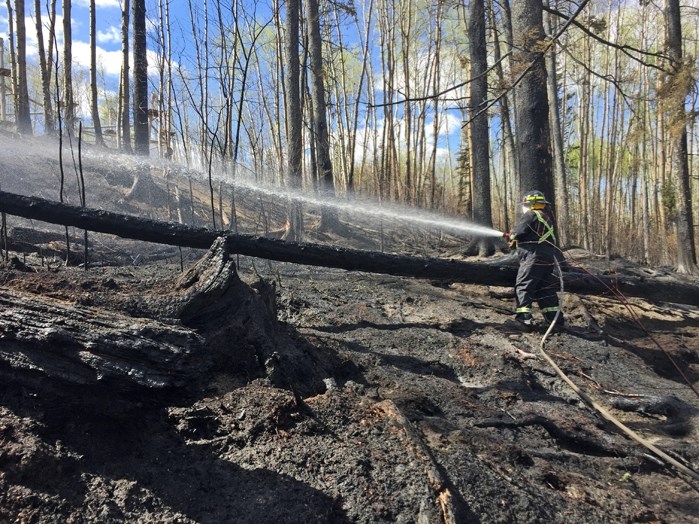 A firefighter from Innisfail-based OP Fire &#038; Safety battles a hot spot near Fort McMurray last week. The company was called to help the hundreds of other firefighters to 