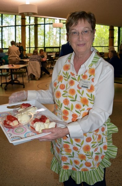 Diane Forslund, a volunteer with the Innisfail and District Health Care Centre Auxiliary, serves up some strawberry shortcake and ice cream during the annual Florence