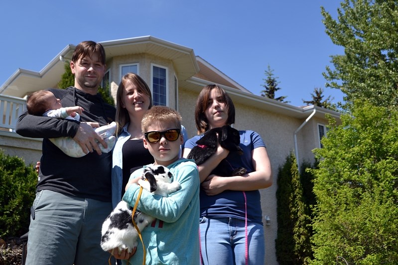 Dan Paron holds his six-week-old daughter Stella, alongside his wife Amy, son Hayden Hilliard-King (front) and daughter Kharma McIver. The Fort McMurray family fled the