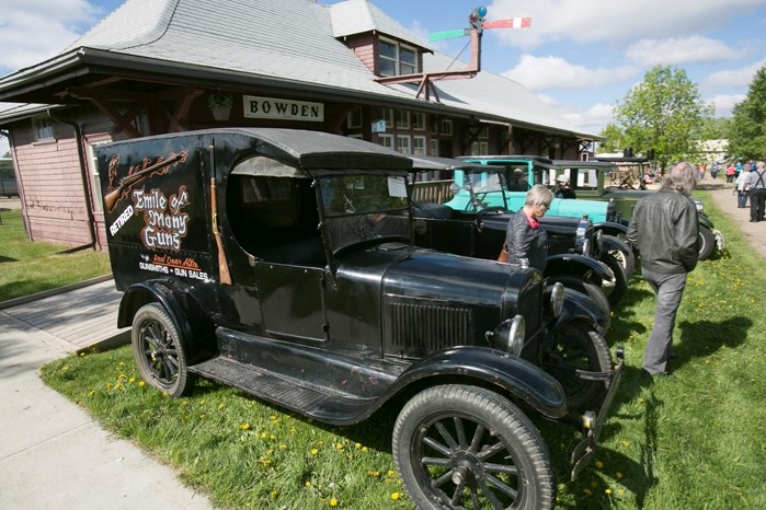 A row of 1920s-era vehicles on display during the historical village&#8217;s vintage vehicle show.