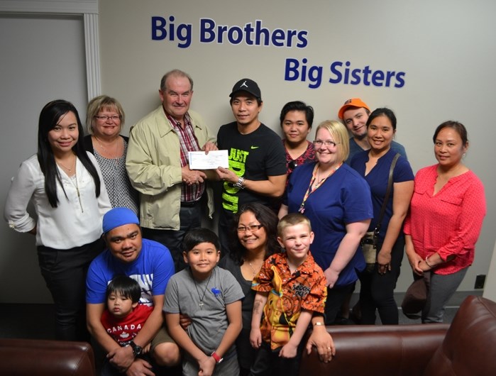 Cris Ting, vice-chair of the Phil-Can Neighbourhood Association of Innisfail, and Tim Howard, executive director of Big Brothers, Big Sisters Prairie to Peaks, are joined by