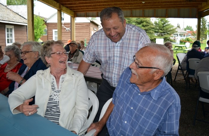 Innisfail mayor Brian Spiller, centre, shares a laugh with Harvey and Gloria Banek during the annual Mayor and Seniors&#8217; Garden Party June 8 at the Innisfail and