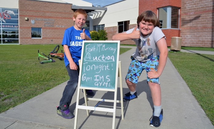 Grade 5 students Devon Holmes, left, and Liam Smith were two of dozens of Innisfail Middle School students helping out with the Fort McMurray community auction on June 16.