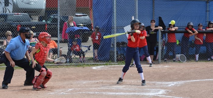 Members of the Innisfail U-12 softball team in action at the plate against Drayton Valley on June 18, while their teammates look on.