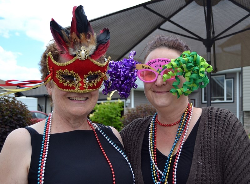 Lauranne Hemingway (left) and Pamela Williams had their Mardi Gras masks on early for this year&#8217;s block party on 49th Street Close.