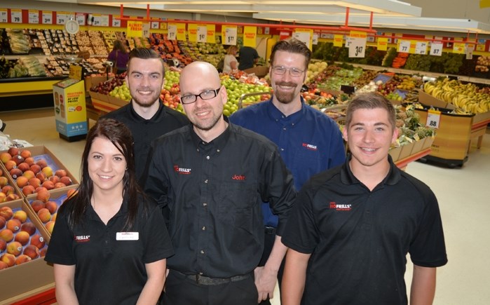 John Harris, centre, is surrounded by some of his workers at his new store John&#8217;s nofrills in Innisfail. Harris took over as owner earlier from previous owner Kevin