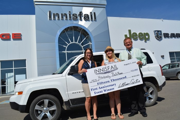 Kim Bellerose, centre, is all smiles as she is presented with a cheque for the $15,000 grand prize she won at Innisfail Chrysler Dodge Jeep Ram earlier this month. Joining