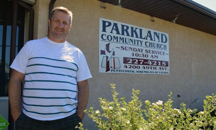 Pastor Gerald Bradbury of the River of Life Church in Innisfail stands in front of the former church sign that will soon be replaced with a new one when it is officially