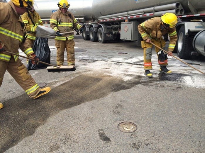 Firefighters with the Penhold Fire Department work to clean up a fuel spill at the Centex gas station in Penhold on Sept. 30.