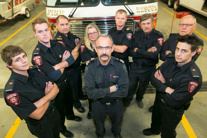 Innisfail Fire department deputy chief Tim Ainscough surrounded in solidarity by members. From left are Jayden Halls, Ian Holsworth, Kevin Fedorchuk, Michelle Carroll, Mike