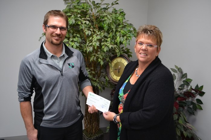 Sherry Dijkstra, the executive director for Big Brothers Big Sisters Prairies To Peaks Association, accepts a $4,700 donation cheque last week from Jeffrey Verhaeghe, general 