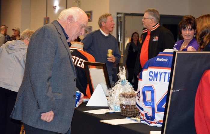 Peter Maher, the former voice of the Calgary Flames looks over auction items during the 3rd annual Sportsman Dinner at the Innisfail Royal Canadian Legion on Oct. 7.