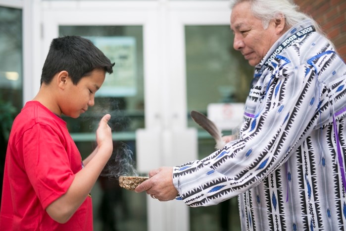 Innisfail Middle School Grade 8 student Matthew Julian takes part in a smudging ceremony facilitated by elder John Sinclair at the start of an Indigenous Youth Conference