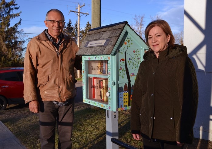 Bud and Bethany Sargent at the Neighbourhood Library box the couple created last summer. It was placed last week by the hall entrance of the Innisfail United Church, near the 