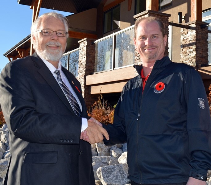 Don MacIntyre, MLA for Innisfail-Sylvan Lake, left, congratulates Darren Black, club manager at the Innisfail Golf Club, after the club received a provincial grant for