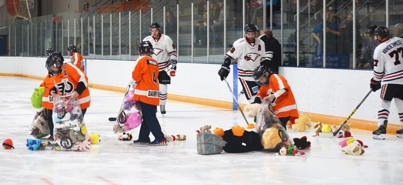 Members of Innisfail Minor Hockey help pick up stuffie toys during the Innisfail Eagles&#8217; annual toy toss on Nov. 25. All of the toys collected that weekend went to the