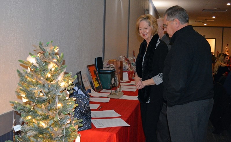 Guests at the Big Brothers Big Sisters of Prairies to Peaks fall gala look over silent auction items on Nov. 25. The annual fundraiser raised about $11,000 for the local