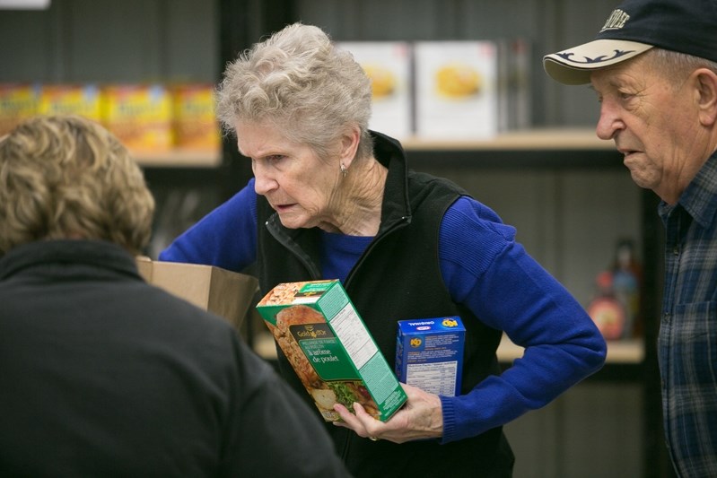 Volunteers Bea, middle, and Mike Humeniuk unload food items at the Innisfail and District Food Bank.