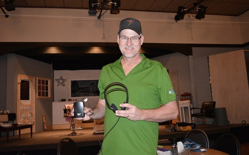 Ron Kooy, a technician with Innisfail Town Theatre, holds a portable induction receiver and headset that will help theatre patrons hear actors during ITT productions. The new 