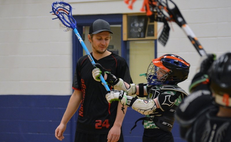 Flow Bros Lacrosse instructor Trey Christensen, left, coaches a player during a recent winter lacrosse practice. Flow Bros Lacrosse works with Innisfail Minor Lacrosse