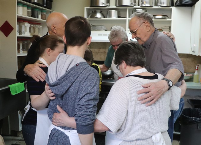  Soup kitchen staff gather for a prayer before serving breakfast.