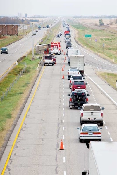 Traffic along the QEII at Hwy. 27 was slowed to a crawl for several hours on Oct. 6 after a 48-ft. tractor-trailer hauling wood chips tipped over at around 11:30 a.m. as it