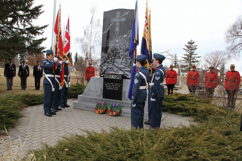 Air cadets and RCMP members stand on guard at the cenotaph.