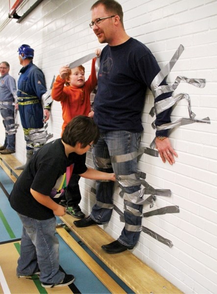 Students duct-taped vice-principal Kory Sholdice to the gym wall to raise money for school recycling.