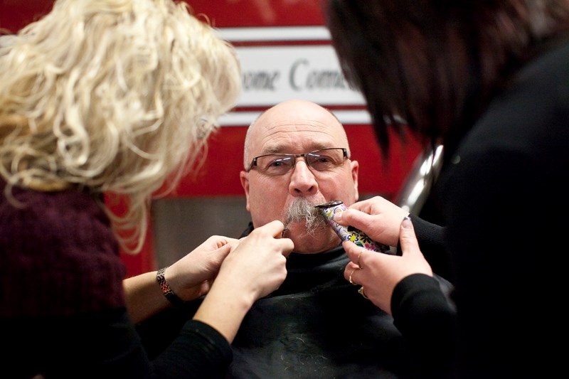 Lynn Roberts gets his mustache shaved off at the Olds fire hall last Wednesday after raising the highest sum of $1,500 as part of the Movember fundraising challenge.