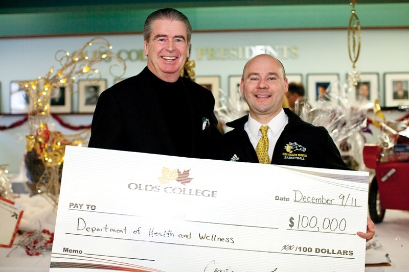 Olds College president Tom Thompson presents a cheque for $100,000 to Greg Lendvay last Wednesday at Olds College.