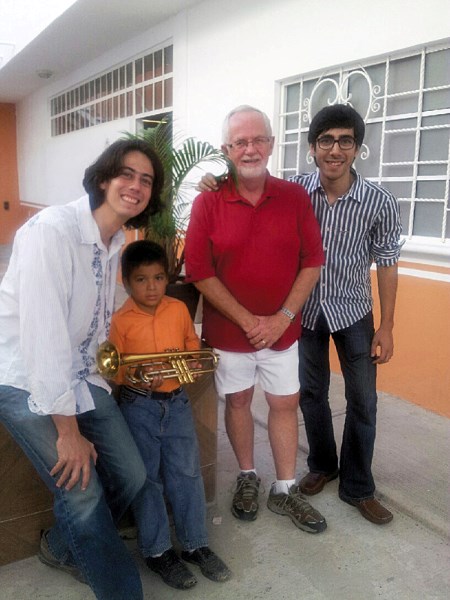 (From left) Miguel Molina, director of the Puerta Vallarta Youth Orchestra, Barry Valleau and Daniel Oliveros, the orchestra&#8217;s assistant director pose with a young