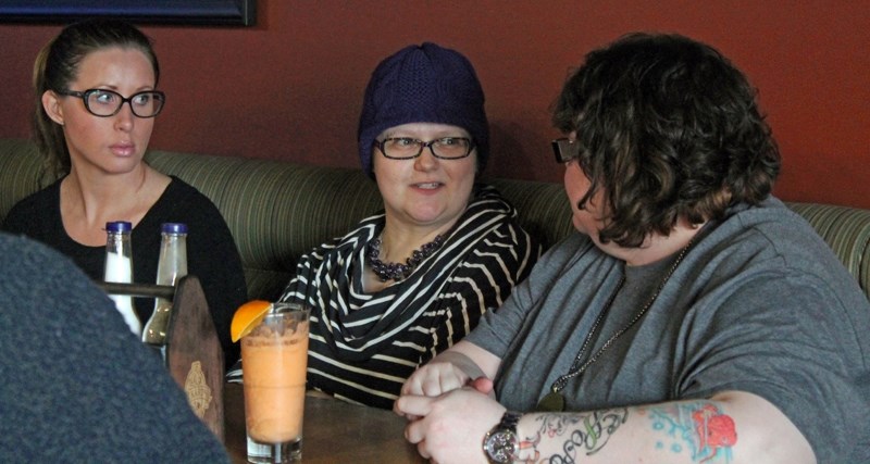 Andrea Barker (centre) chats with friends during a Boob Tour fundraiser for her at Boston Pizza on April 20.