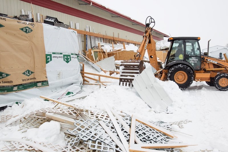 An excavator operator clears away snow and debris on Jan. 7 from a section of a building that collapsed at Home Hardware. CLICK ON PICTURE TO ENLARGE PHOTOGRAPH.