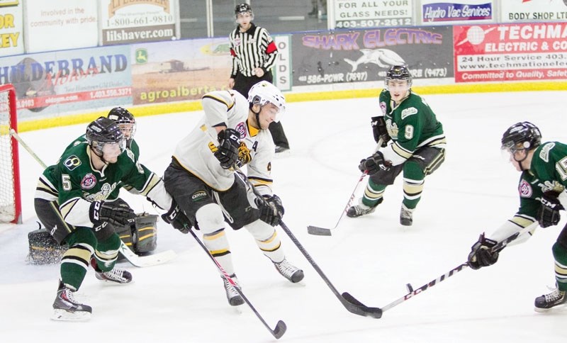 Olds Grizzlys player Austin Kernahan fights for possesion of the puck with Okotoks Oilers player Kevin Jenken during Game 3 of the teams&#8217; playoff series at the Olds