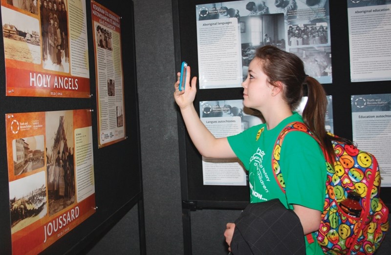 Olds High School student Rachelle Fullerton-Lee examines displays chronicling Canada&#8217;s residential school system during a Truth and Reconciliation event in Edmonton on