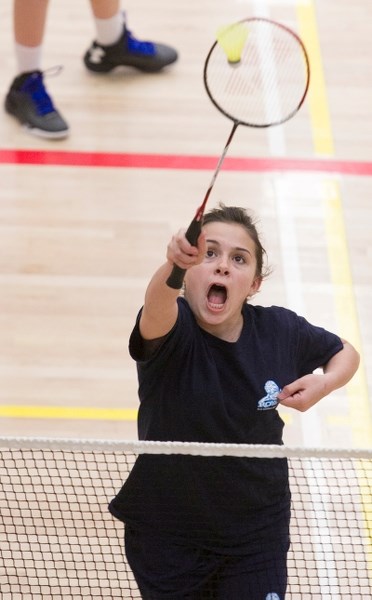 Olds Koinonia Christian School Grade 7 student Sam Shortt returns the shuttlecock during a doubles match with partner Faith Roy (not shown) during a county badminton