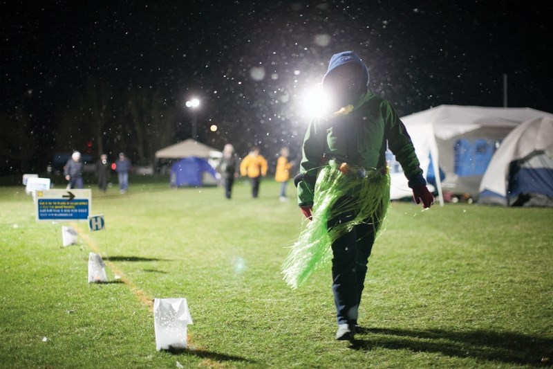 A paricipant looks at one of the luminaries lit during the Olds Relay for Life while walking around the track lat the Community Learning Campus soccer field late on May 2.