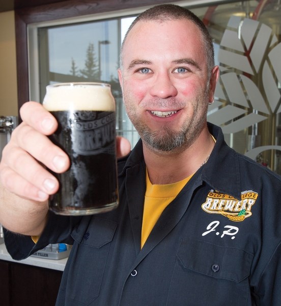 Olds College brewery student Jason Popesku holds a glass of #10 Browning Street, which was recently voted as the 2014 &#8220;Rookie of the Year&#8221; brew at the Calgary