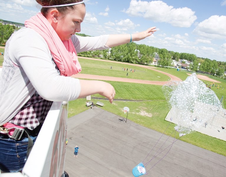 Ecole Deer Meadow School Grade 6 student Zoe Chambers drops an egg secured in a package she designed for the Egg Drop competition at the school on June 6. The Olds Fire