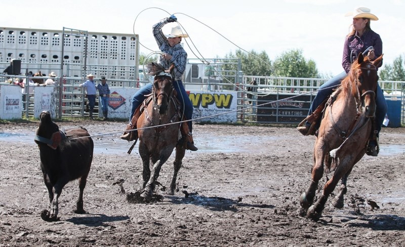 Sarah and Angie Thompson ride hard during the Bowden Daze rodeo team roping event on July 26. CLICK ON PHOTO FOR LARGER IMAGE