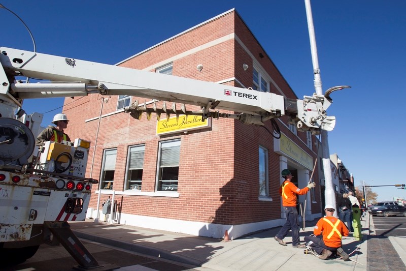 Workers install a light standar at the corner of 50 Street and 51 Avenue on Oct. 8.