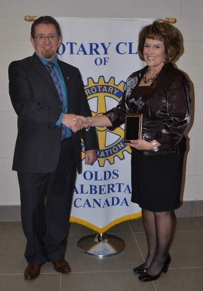 Kathy Kemmere (right) receives her Humanitarian of the Year award from Olds Rotary Club president Norm McInnis.