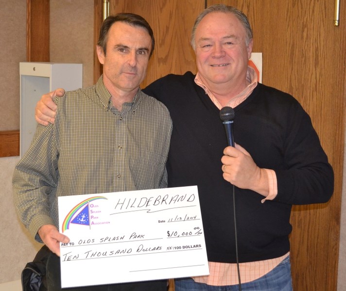 Keith Hildebrand (left), general sales manager at Hildebrand Motors, presents a cheque for $10,000 to Olds Splash Park Association president Brien McDonald.