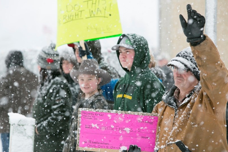 People line the street outside the Cow Palace Dec. 9 as a convoy of vehicles enters Olds after driving up from the Carstairs area.