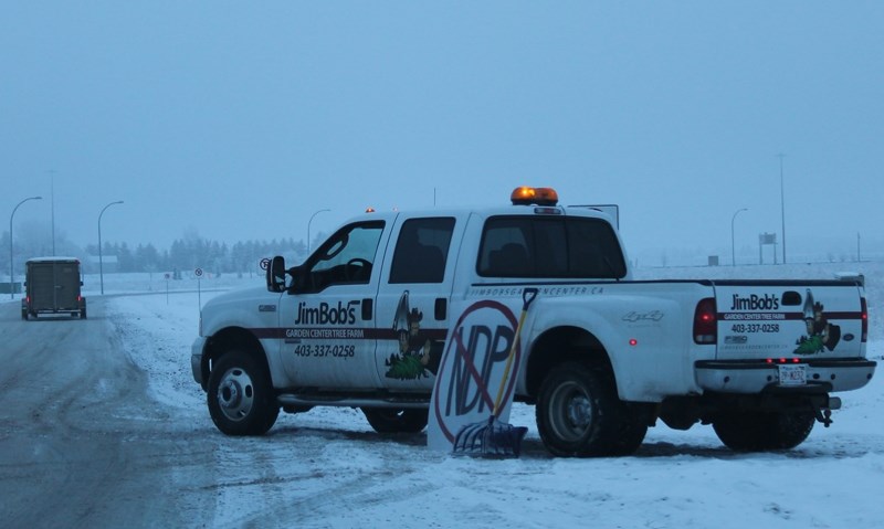 Jim Bob Thain directs farm vehicles to the protest cavalcade rendezvous for the Bill 6 and NDP farm policy protest on Dec, 12. The farmers opted to stay off Highway 2 for